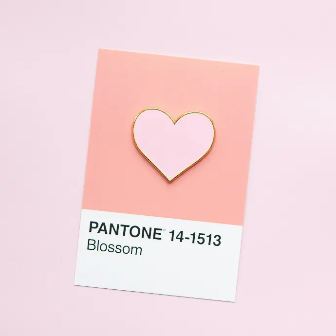 a pin with a pink heart on it